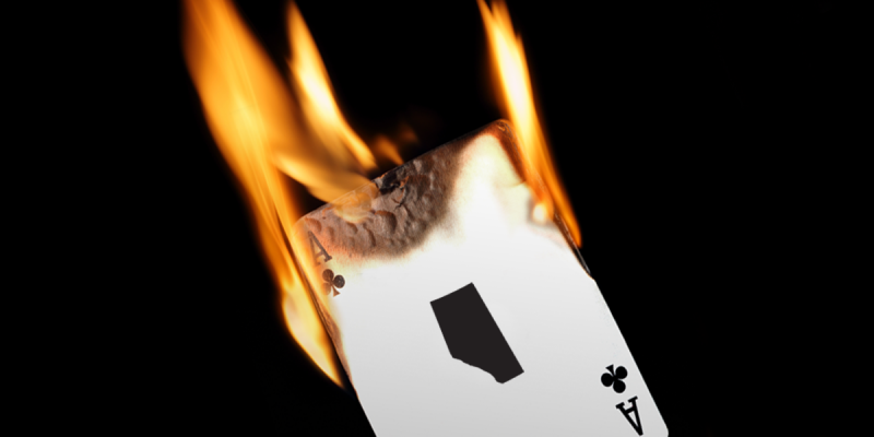 An ace of clubs playing card, with the province of Alberta in place of an &quot;A,&quot; is lit on fire.