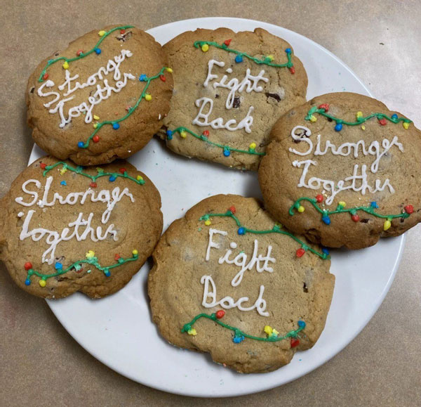 Christmas cookies decorated with phrases such as "Stronger together," and "Fight back"