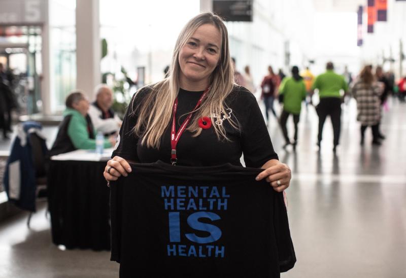A Local 003 delegate hold up a t-shirt that says &quot;Mental Health is Health&quot;